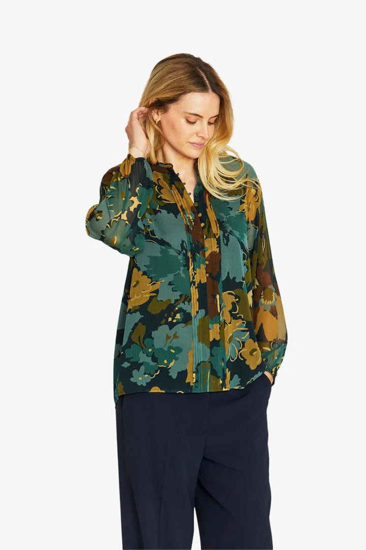 Woman wearing a patterned blouse with a white background