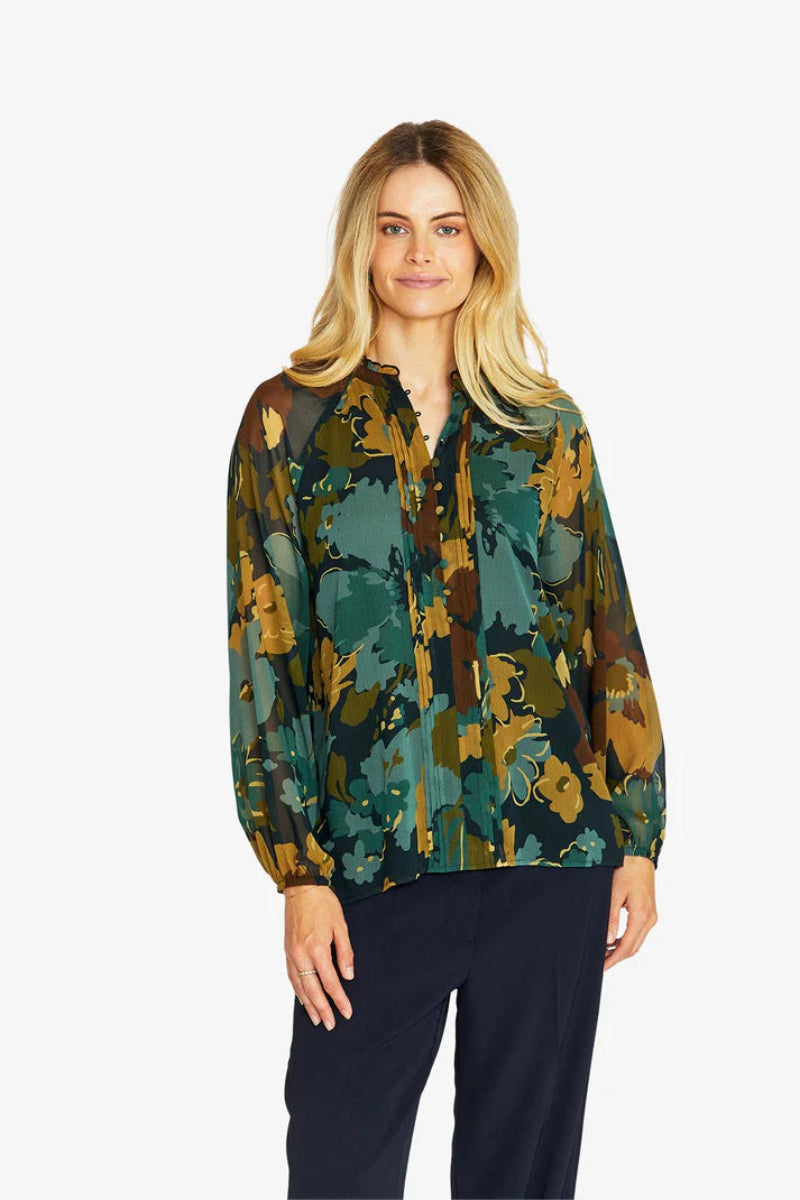 Woman wearing a patterned blouse with a white background