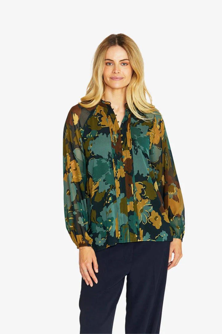 Woman wearing a patterned blouse with a white background