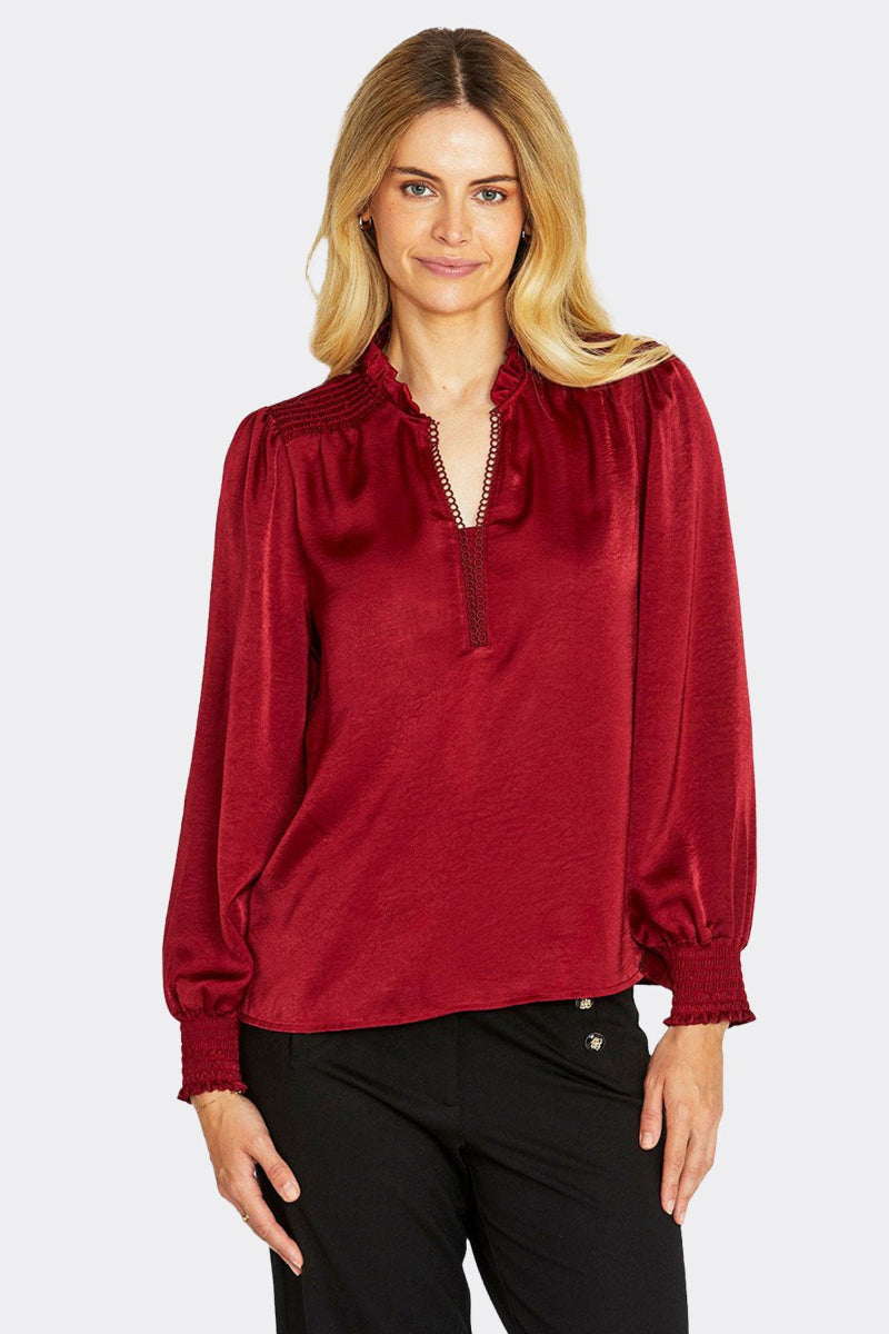 Woman wearing a red blouse with long sleeves on a white background