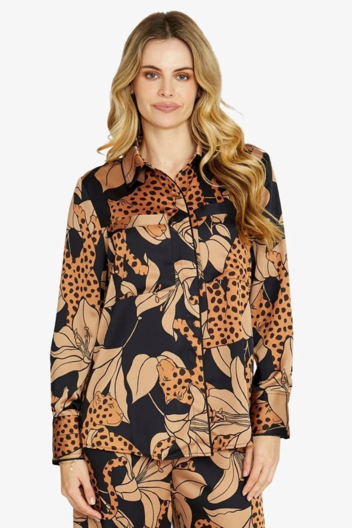 Woman wearing a long-sleeve shirt with a floral and leopard print pattern on a white background
