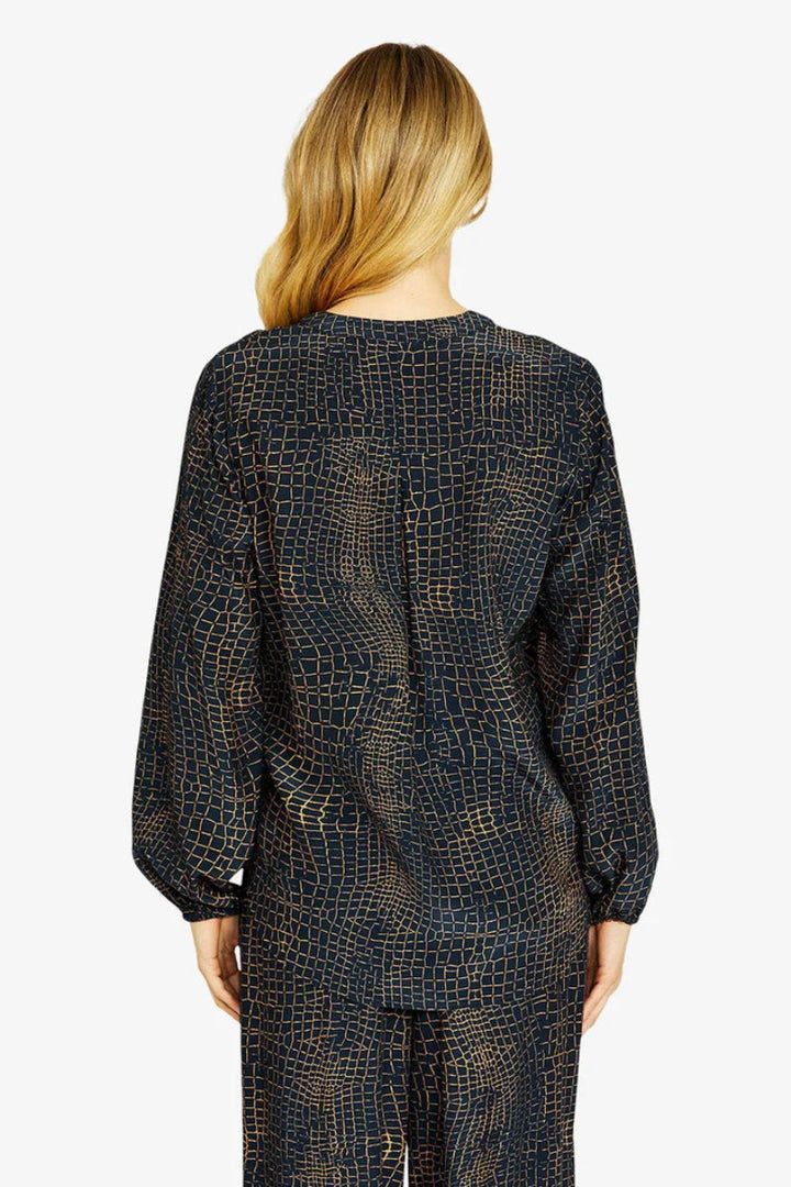 Person wearing a dark patterned outfit on a white background