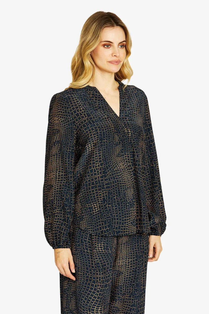 Woman wearing a dark patterned outfit on a white background