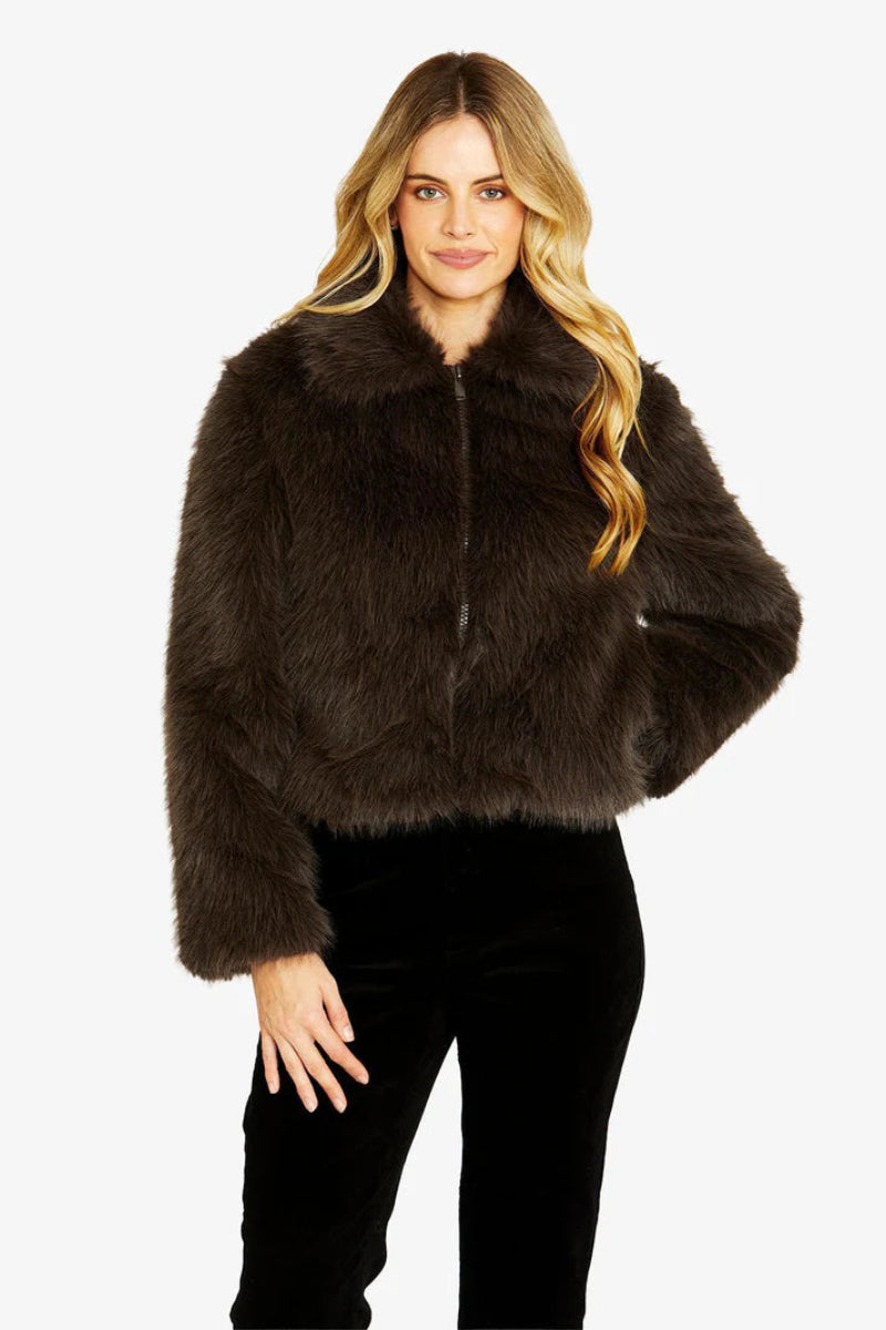 Woman wearing a brown fur jacket on a white background