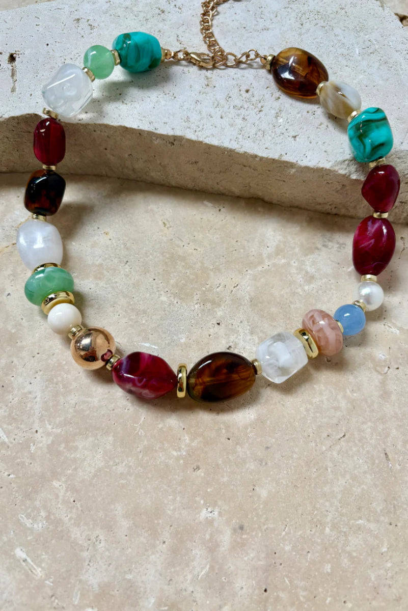 Necklace with multicolored beads on a stone surface