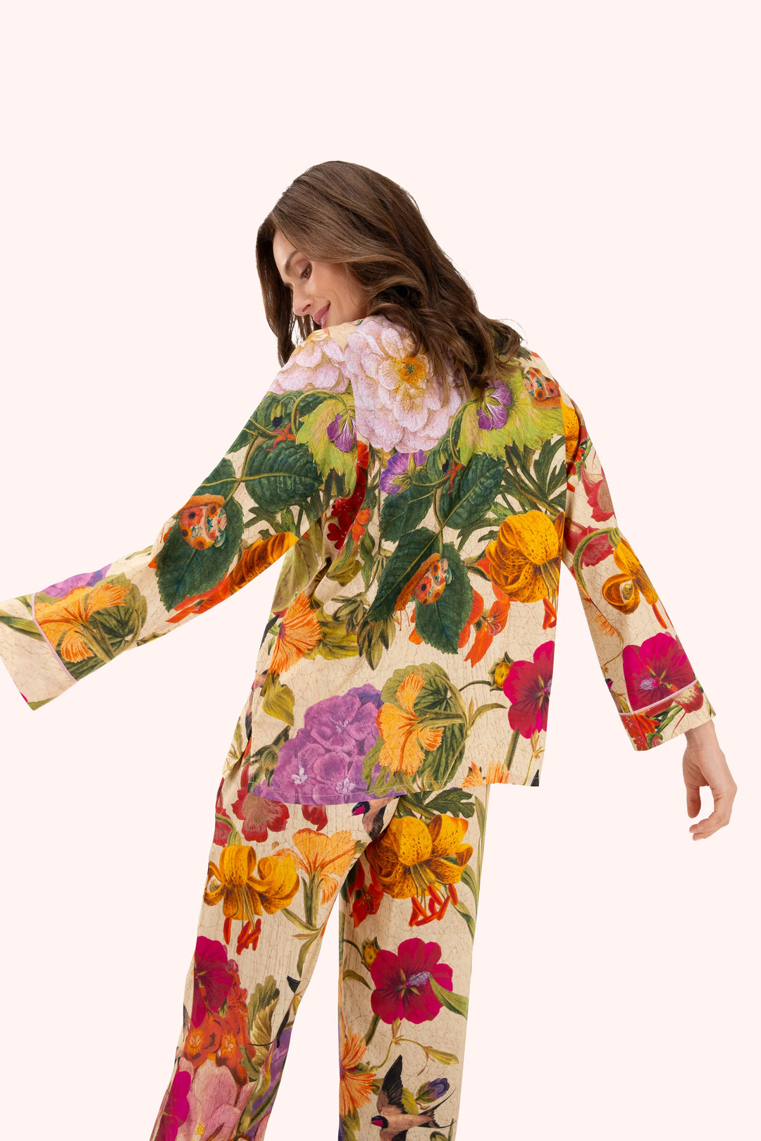 Woman wearing a colorful floral outfit on a white background