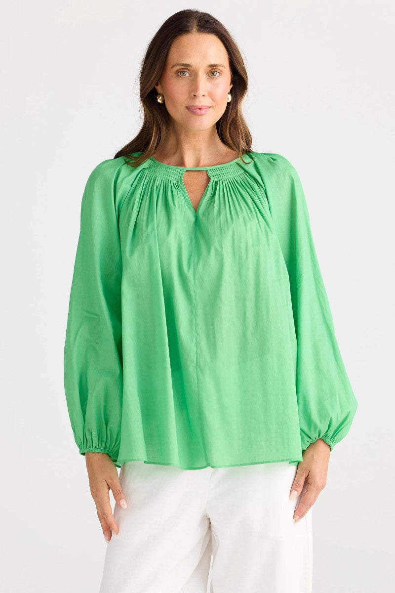 Woman wearing a green blouse with a plain background