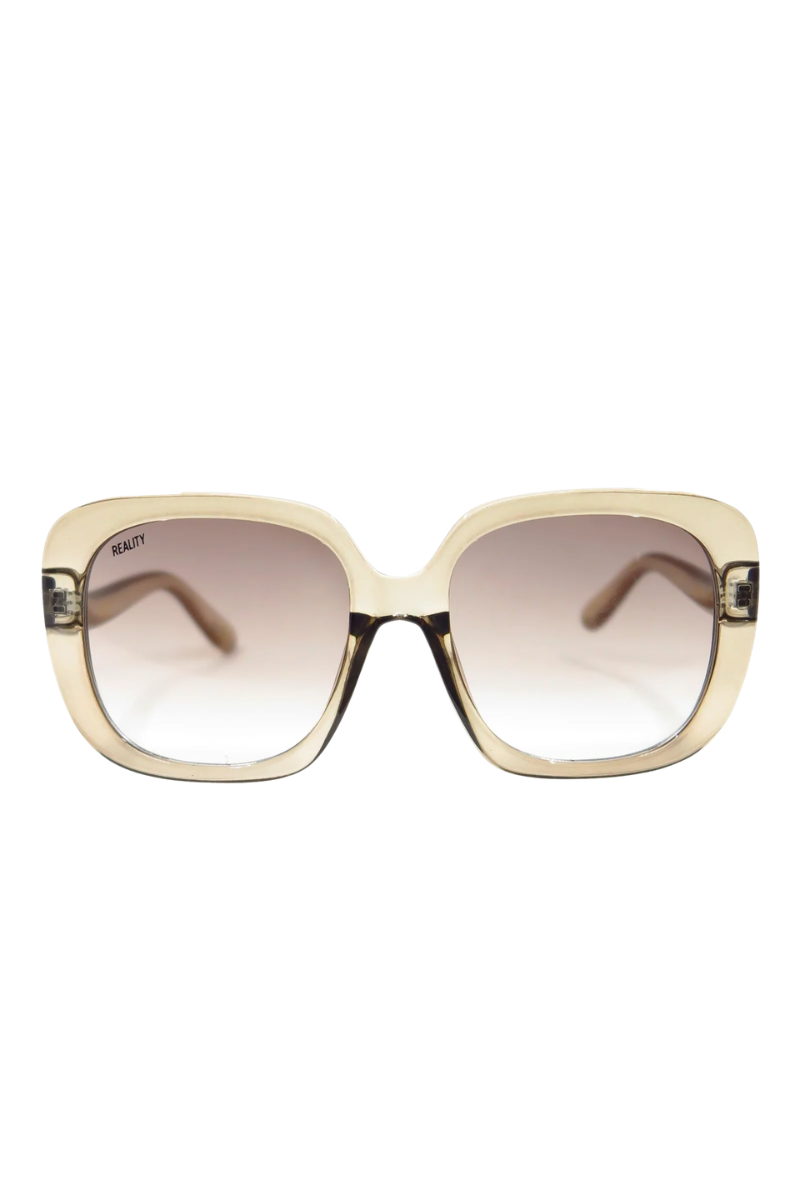 A pair of oversized square sunglasses with a translucent beige frame and gradient brown lenses, shown against a plain white background.