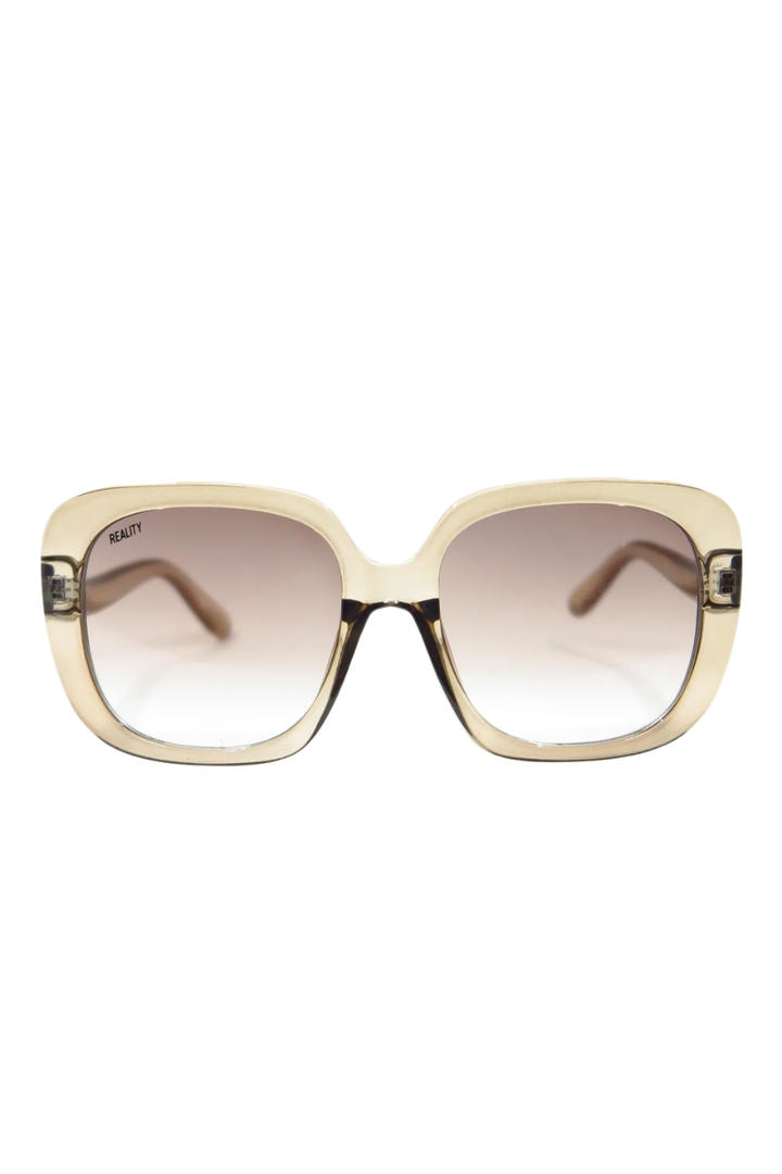 A pair of oversized square sunglasses with a translucent beige frame and gradient brown lenses, shown against a plain white background.