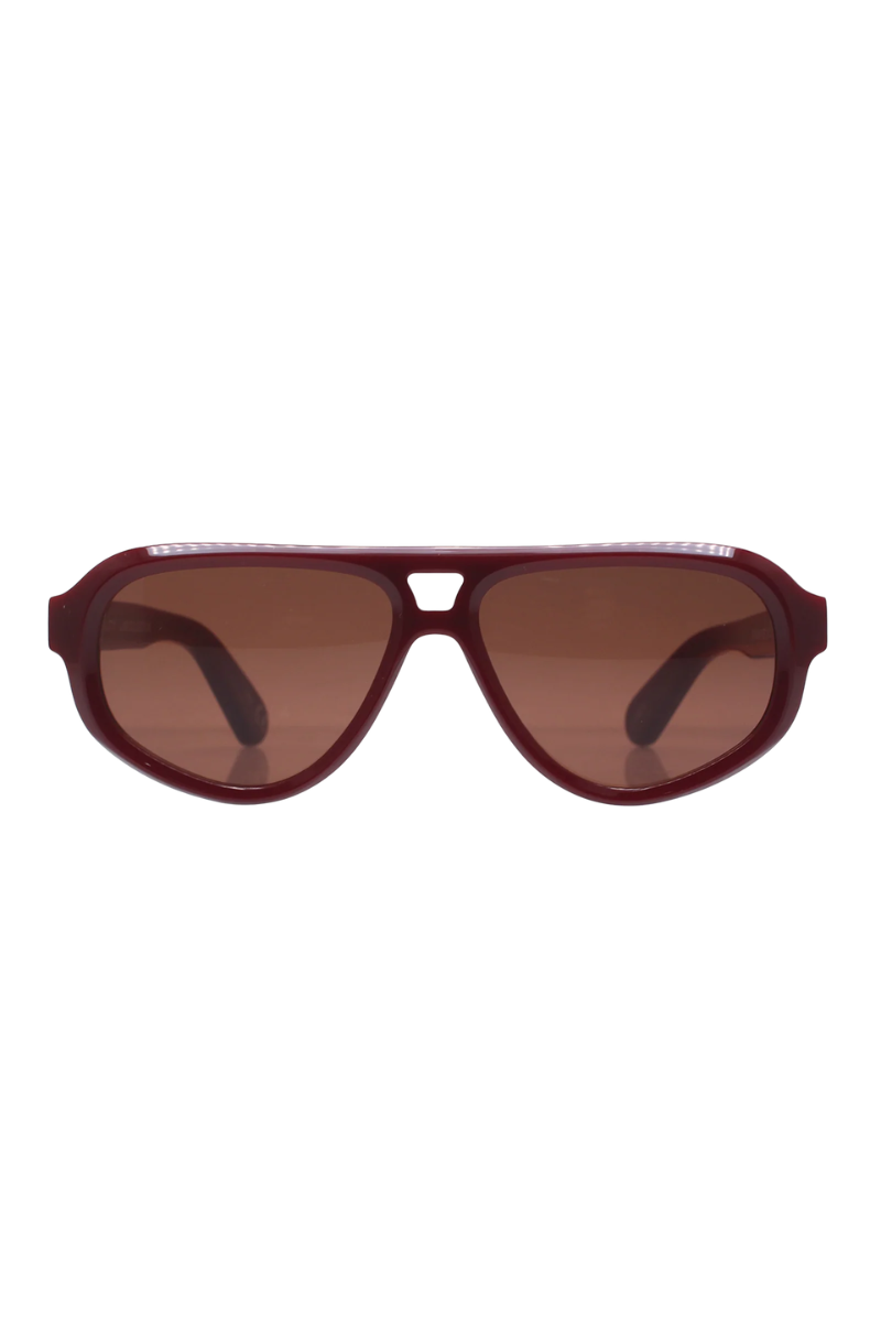 A pair of aviator-style sunglasses with a translucent burgundy frame and brown tinted lenses, shown against a plain white background.