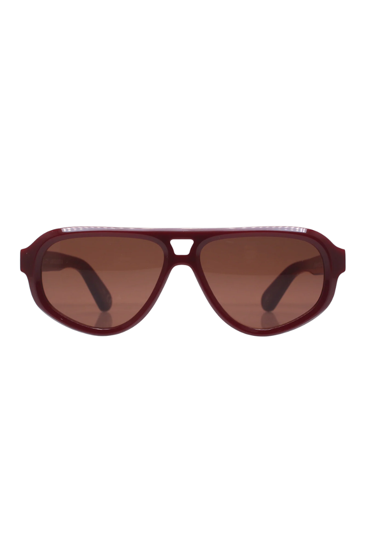 A pair of aviator-style sunglasses with a translucent burgundy frame and brown tinted lenses, shown against a plain white background.