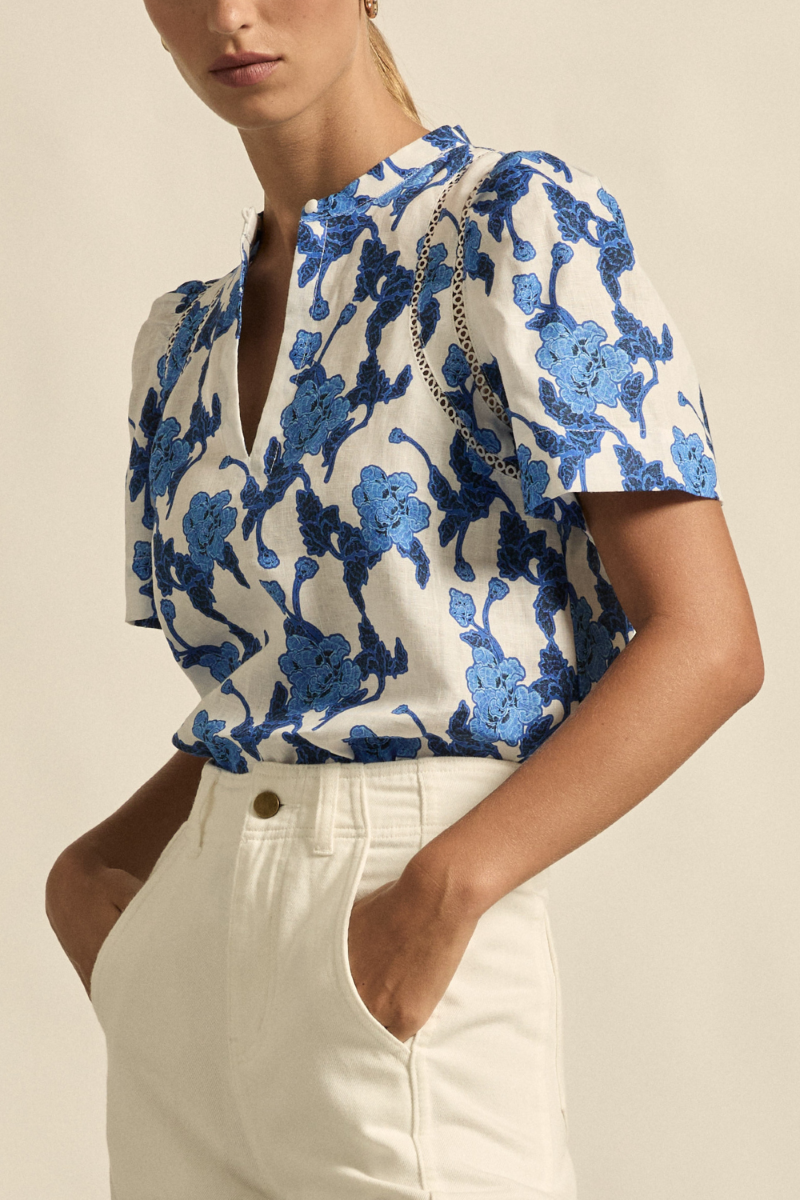 This side close-up of the Recollect Top in Azure Bouquet highlights the soft gathering of the tulip sleeve, intricate lace detailing, and the natural texture of the linen fabric.
