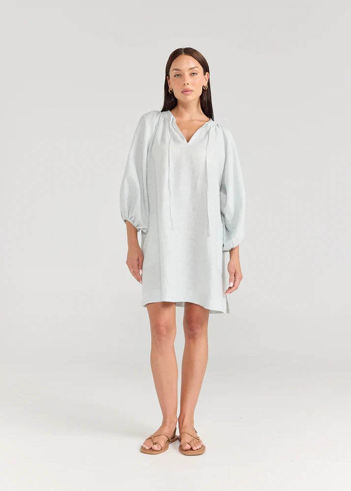 Woman wearing a light blue dress on a white background