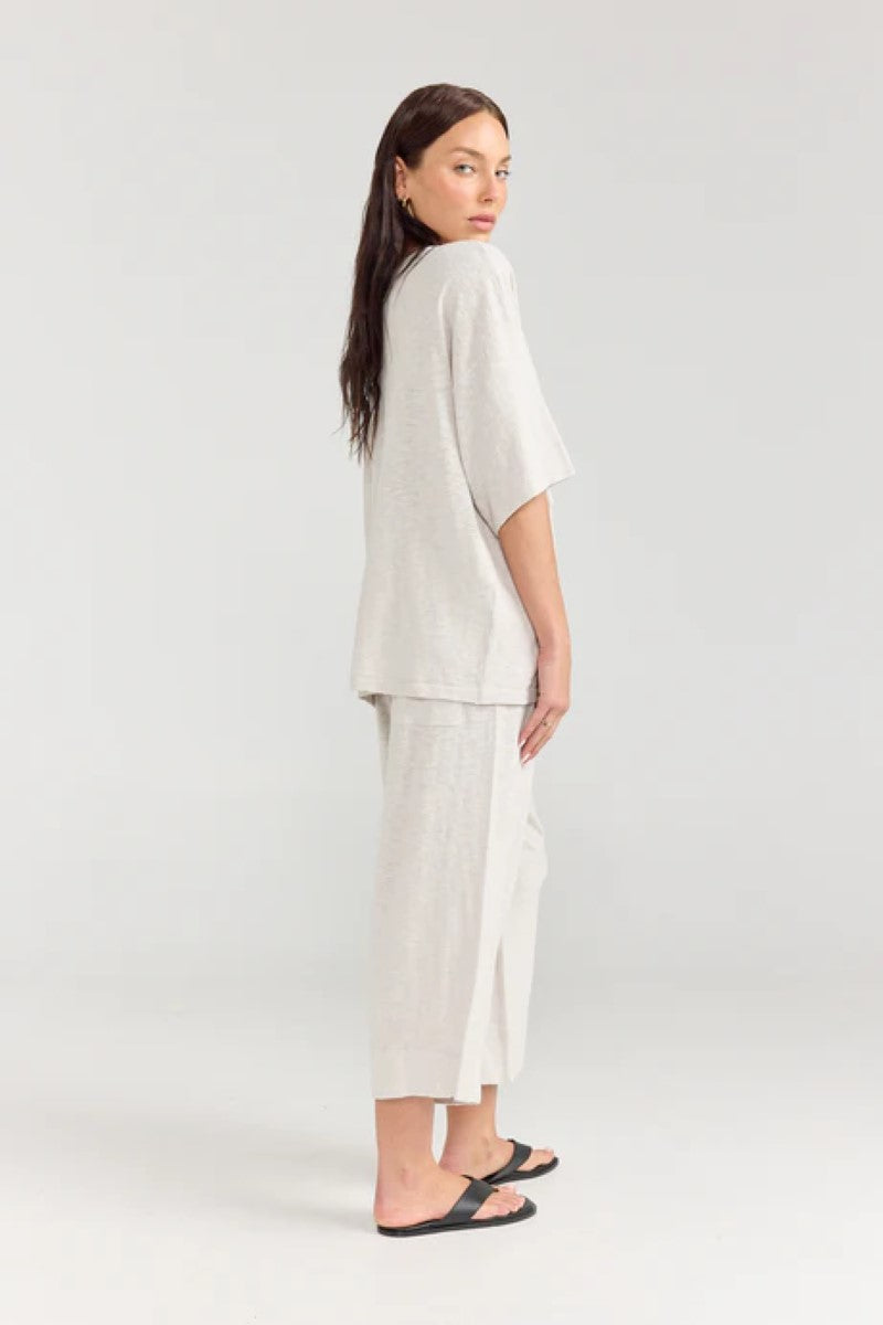 Woman wearing a white outfit on a plain background