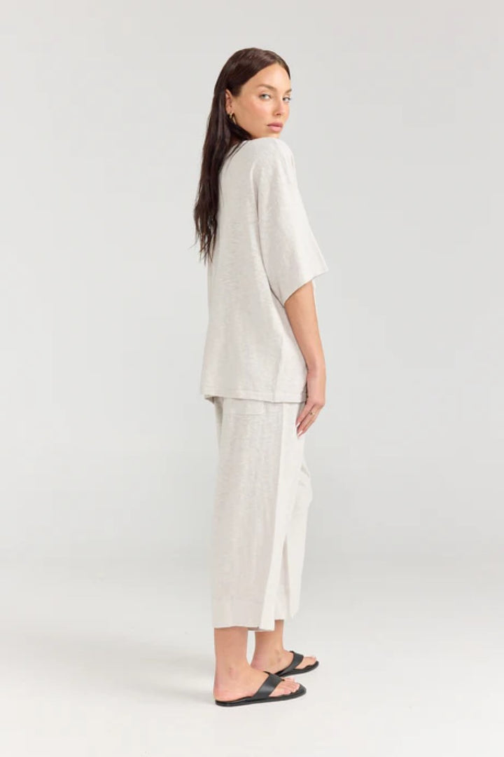 Woman wearing a white outfit on a plain background