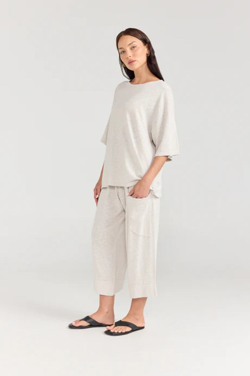 Woman wearing a light gray outfit on a white background