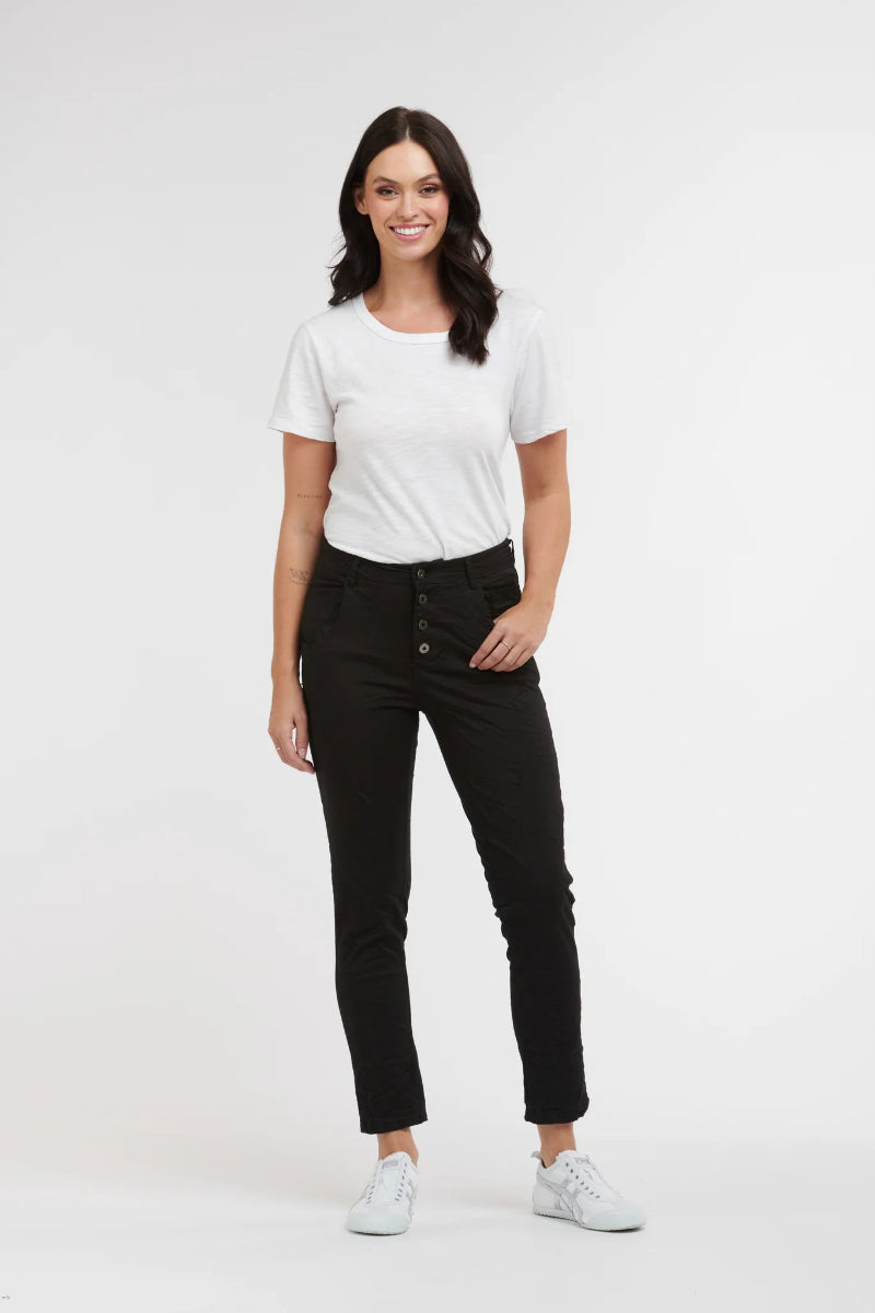 Woman wearing a white t-shirt and black pants on a white background