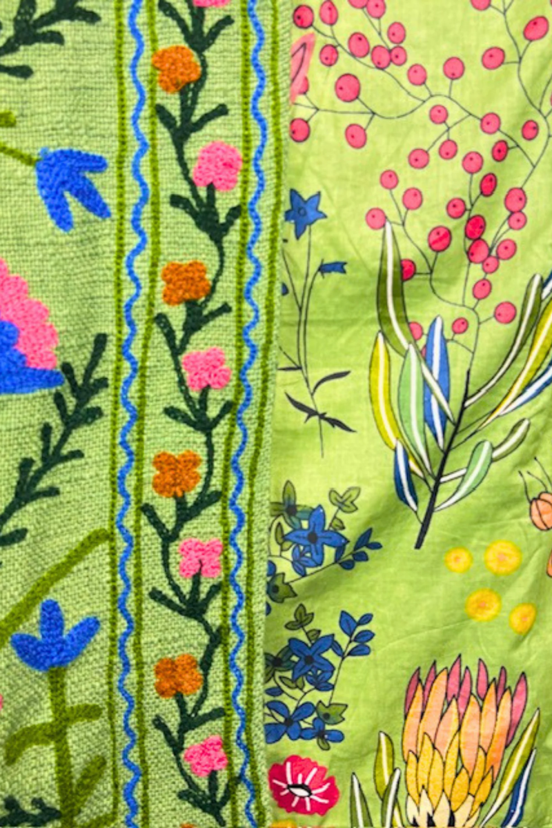 Close-up of a colorful embroidered fabric with floral patterns on a green background