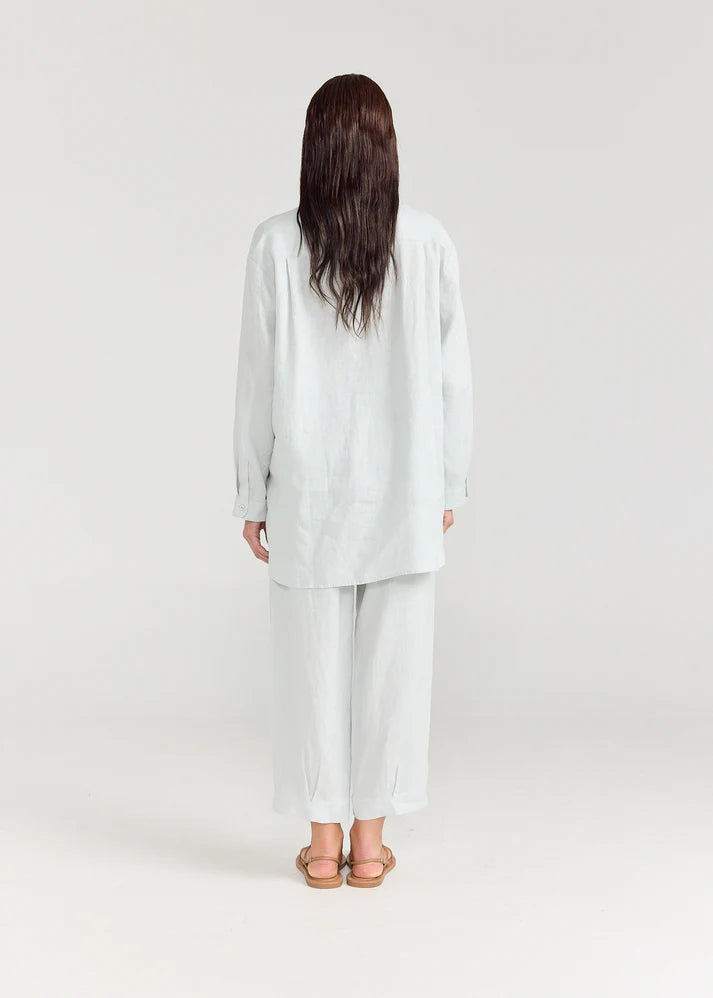 Person wearing a light gray outfit on a white background