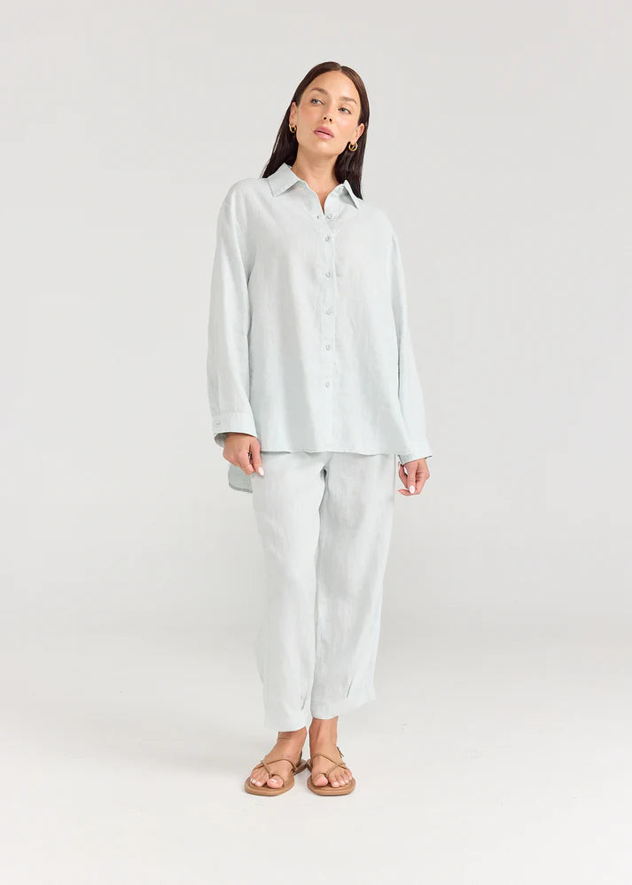Woman wearing a light gray pajama set on a white background