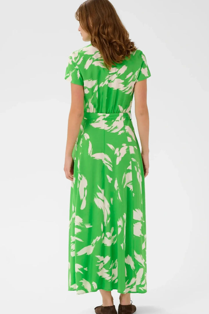 Woman wearing a green and white floral dress on a white background