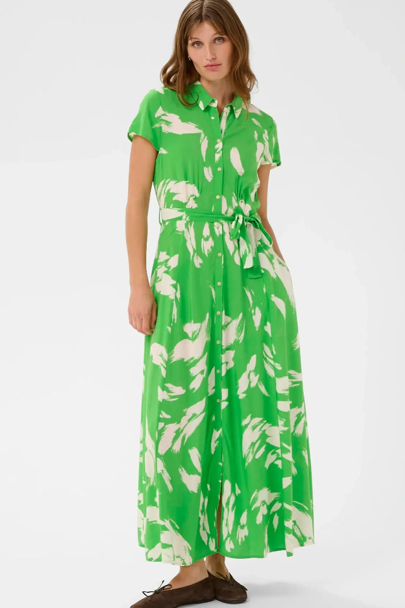 Woman wearing a green dress with white floral pattern on a white background