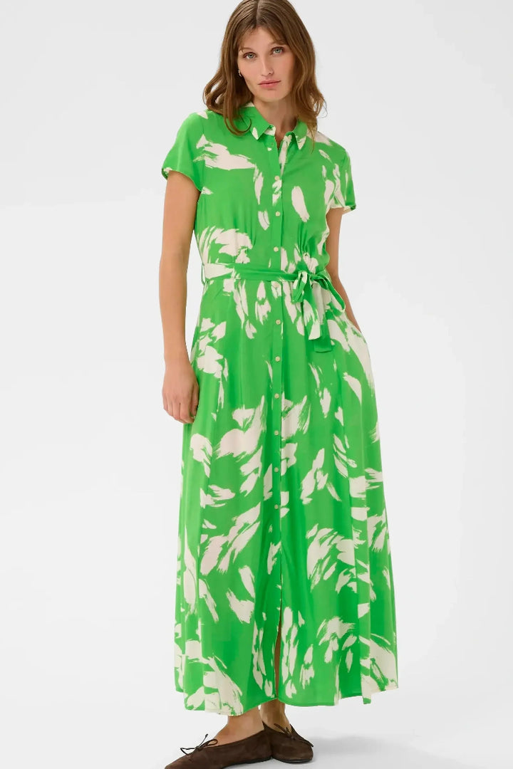 Woman wearing a green dress with white floral pattern on a white background