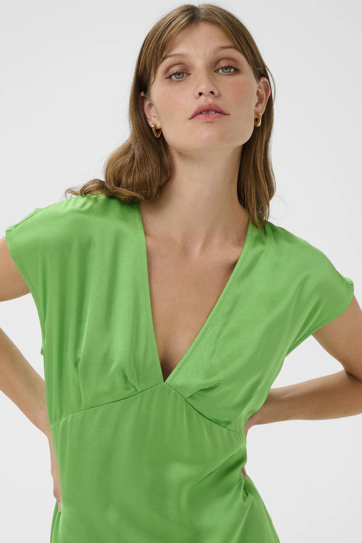 Woman wearing a green dress against a white background