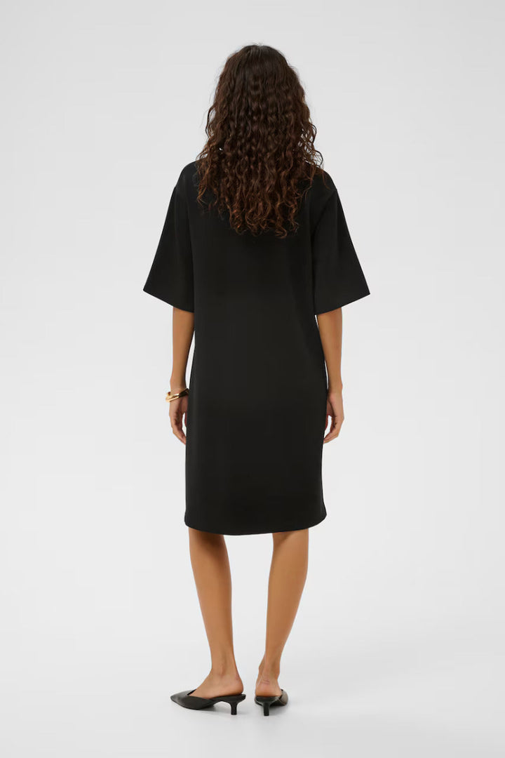 Person wearing a black dress from behind on a white background