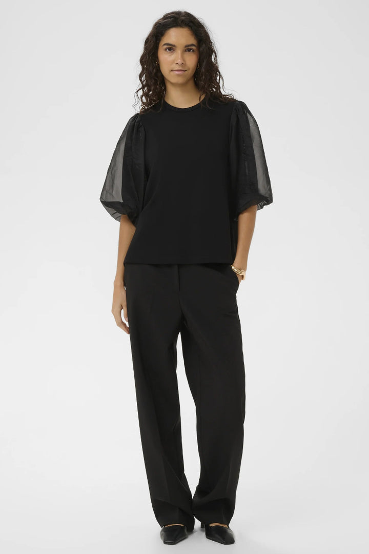 Person wearing a black outfit on a white background