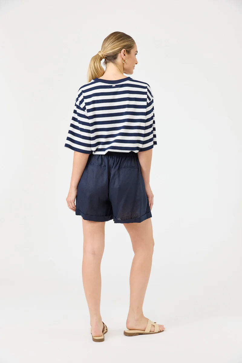 Woman wearing a striped shirt and navy shorts on a white background