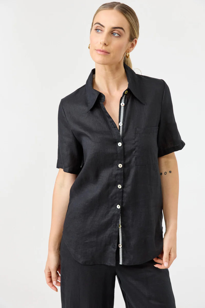 Woman wearing a black short-sleeve button-up shirt against a white background