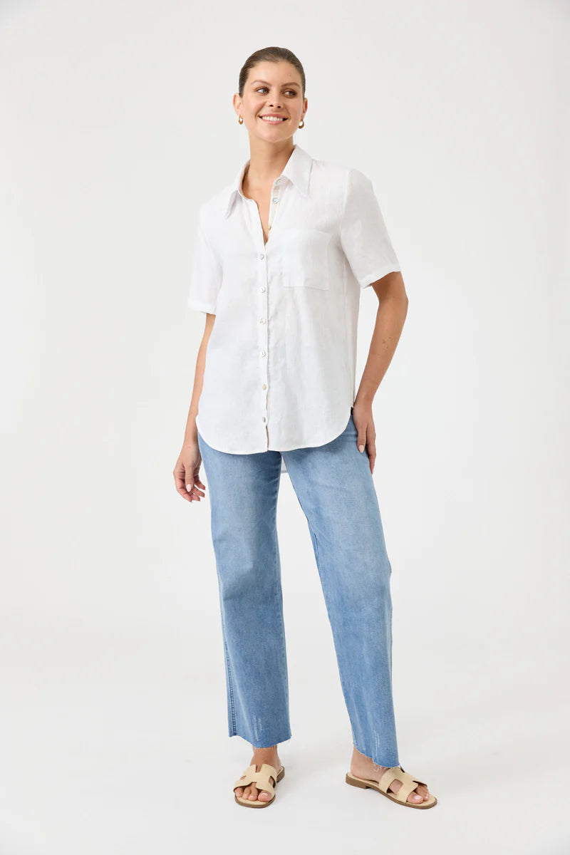 Woman wearing a white shirt and light blue jeans on a white background