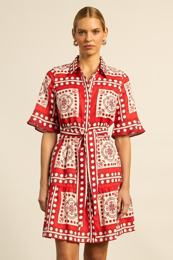 Woman wearing a red and white patterned dress on a beige background