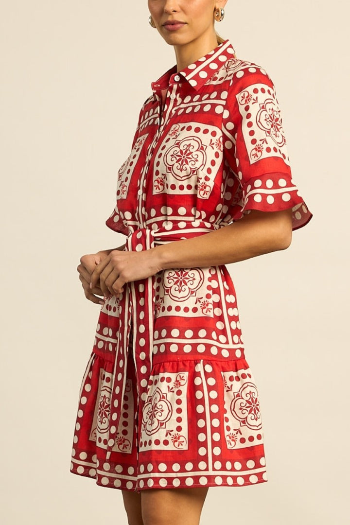Red and white patterned dress worn by a person on a beige background