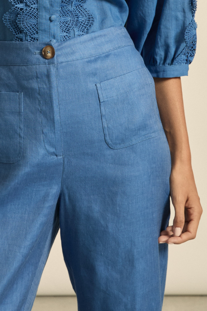 This close-up image of the Syllabus Pant in Shoreline highlights the soft linen blend fabric, curved patch pocket detailing, and the refined tortoise shell button closure.
