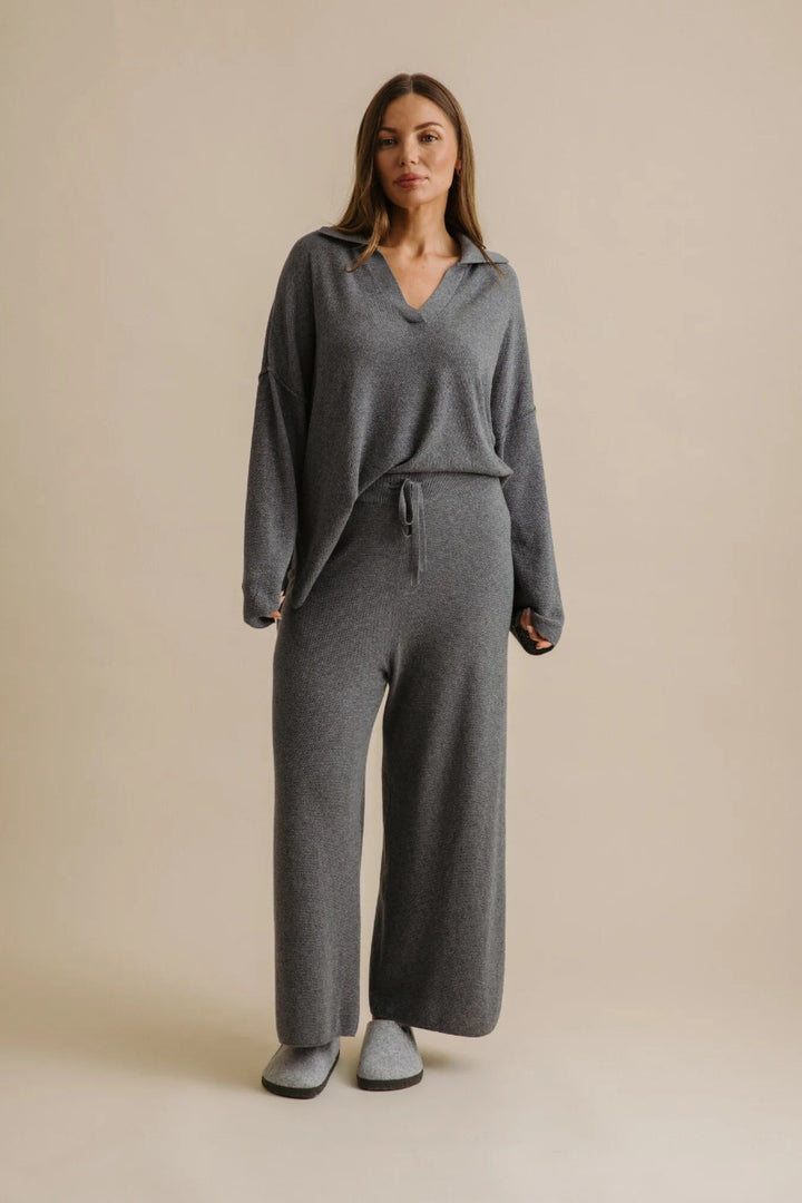 Woman wearing a gray loungewear set on a beige background