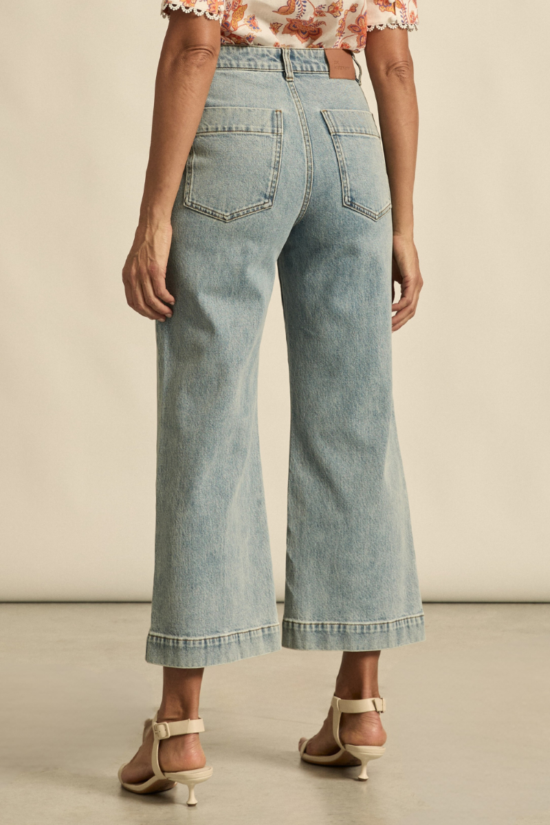 Close-up back view of the Tenure Jean in washed denim, highlighting the back pockets, yoke seam detail, and faded denim texture.