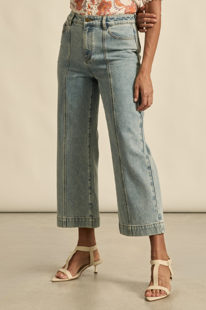 Close-up front view of the Tenure Jean in washed denim, showcasing the classic button and zip closure, front pockets, and detailed denim texture.