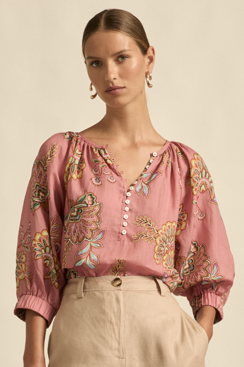 This front close-up view of the Tranquil Top in Kgari Bloom highlights the gathered neckline, delicate shell buttons, and the soft texture of the 100% ramie fabric.
