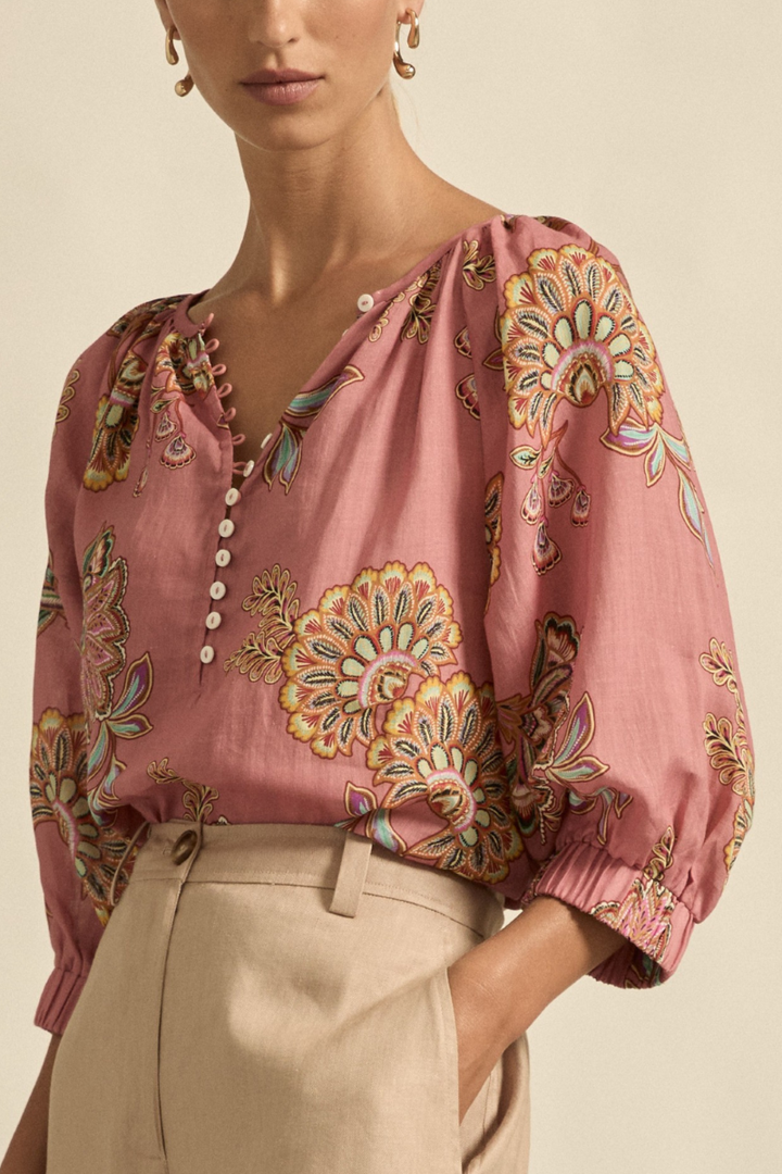 This side close-up view of the Tranquil Top in Kgari Bloom showcases the relaxed raglan sleeve, elasticated cuff, and fine fabric texture for an effortlessly elegant look.
