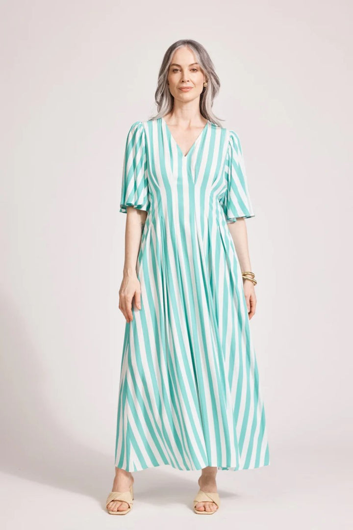 Woman wearing a green and white striped dress on a plain background