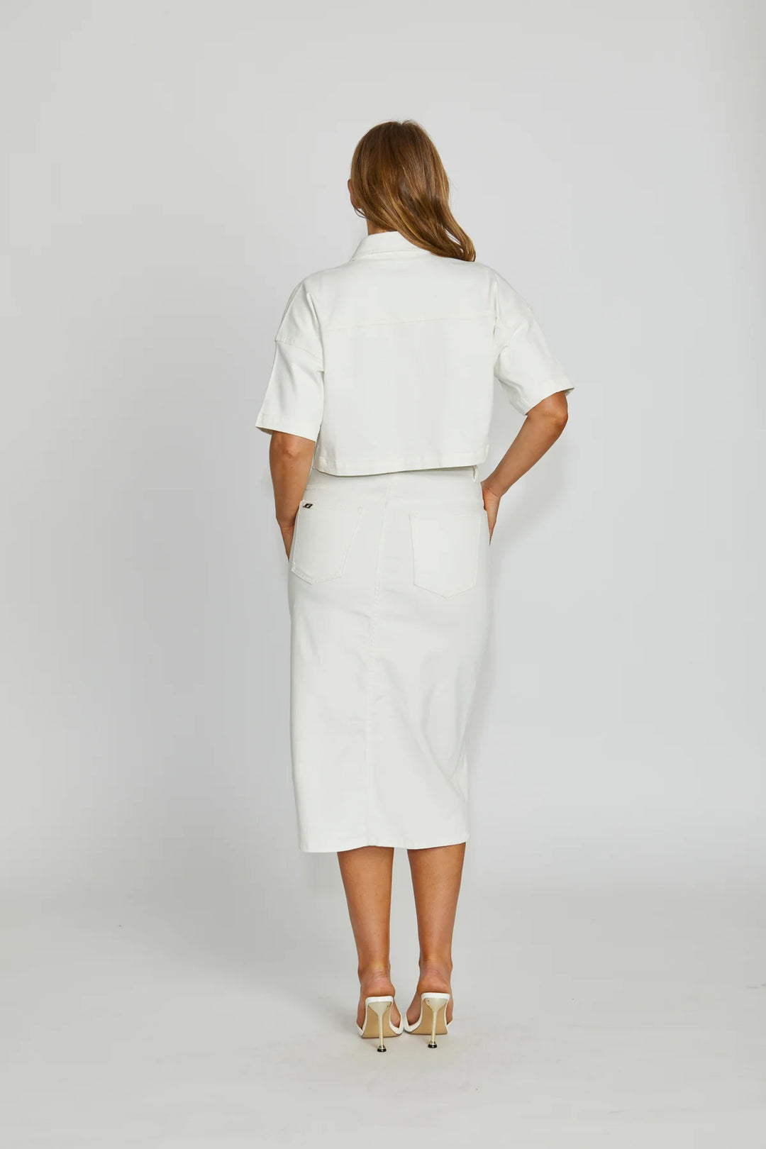 Woman wearing a white outfit on a plain background