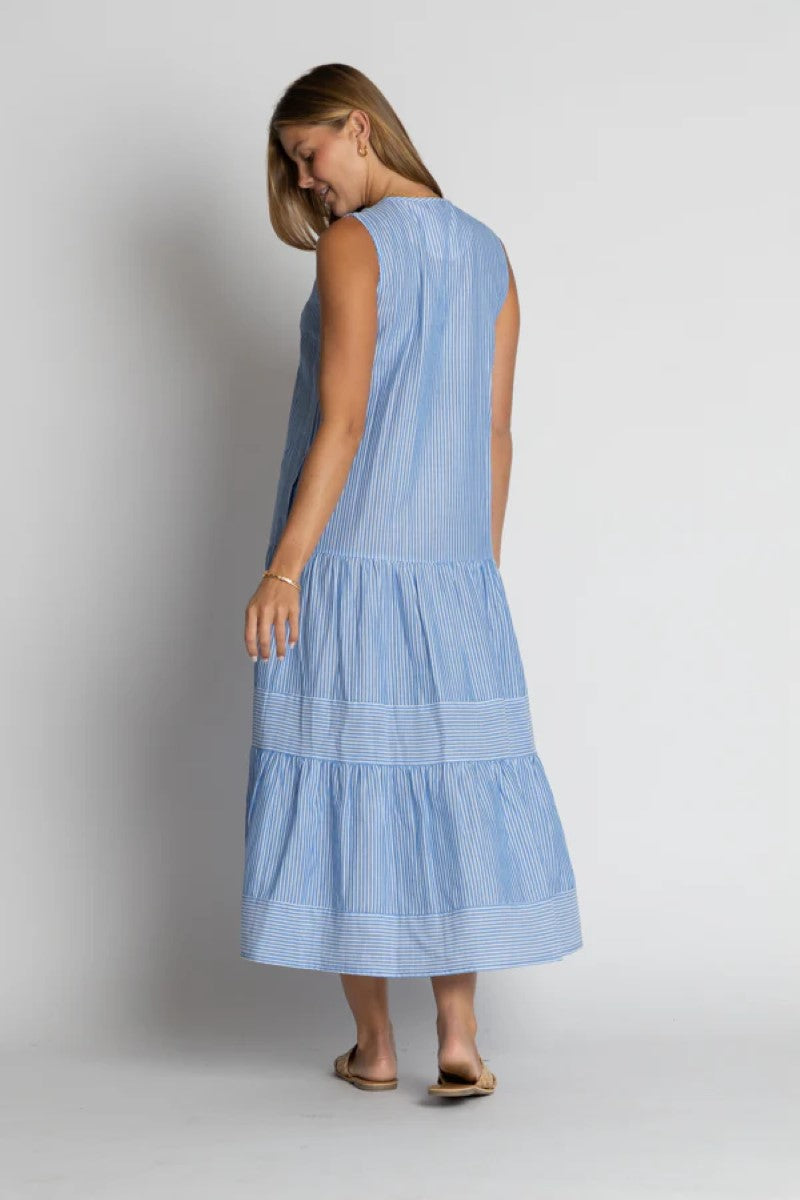 Woman wearing a light blue dress against a plain background