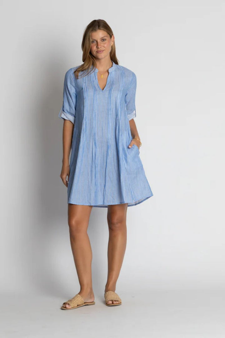 Woman wearing a blue striped dress on a plain background