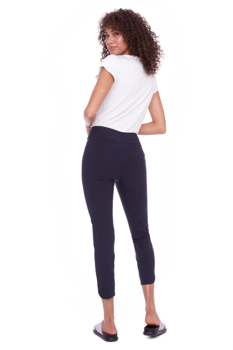 Woman wearing a white top and dark blue leggings on a white background