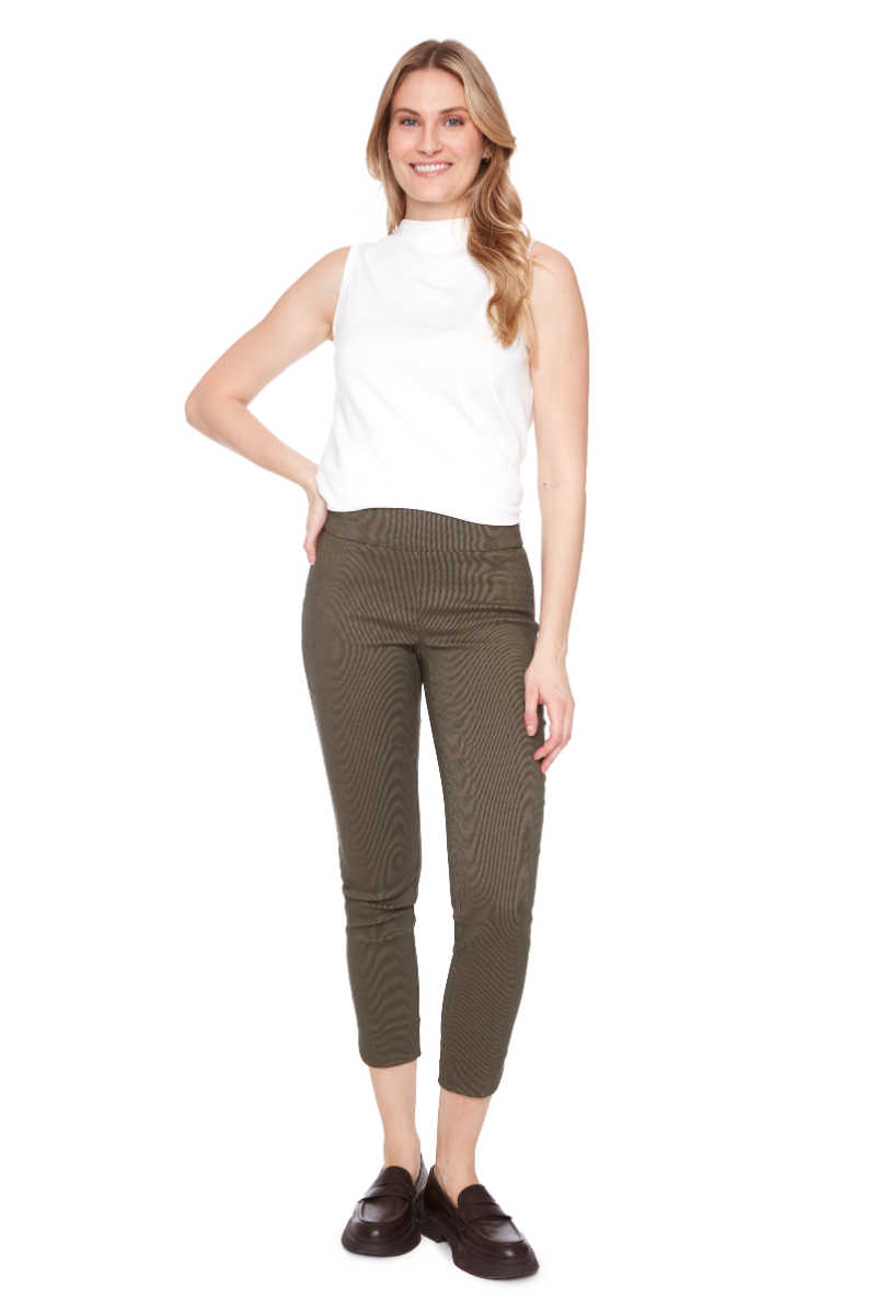 Woman wearing a white sleeveless top and olive green pants on a white background