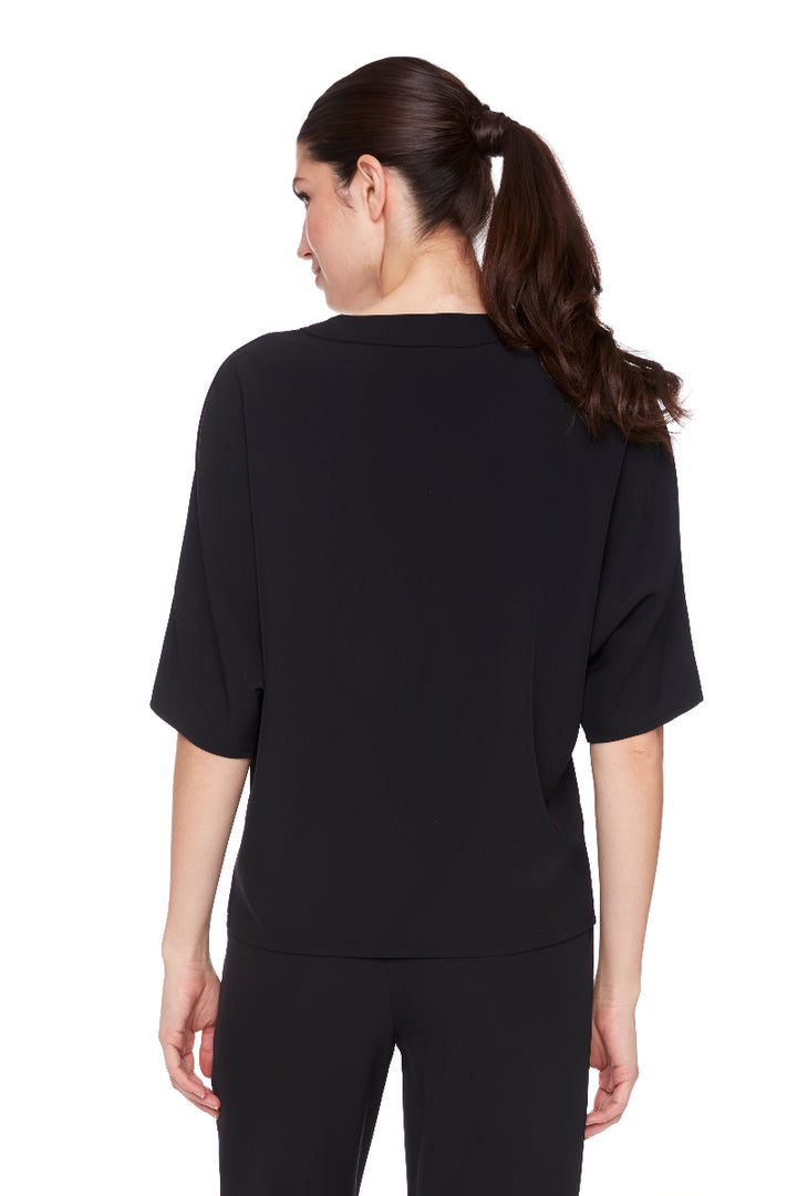 Woman wearing a black top and pants on a white background