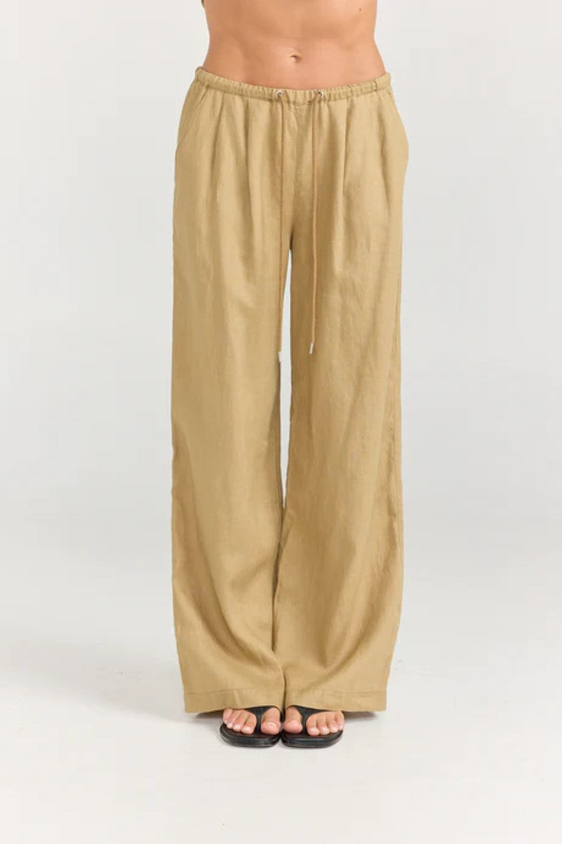 Beige wide-leg pants worn by a person on a white background