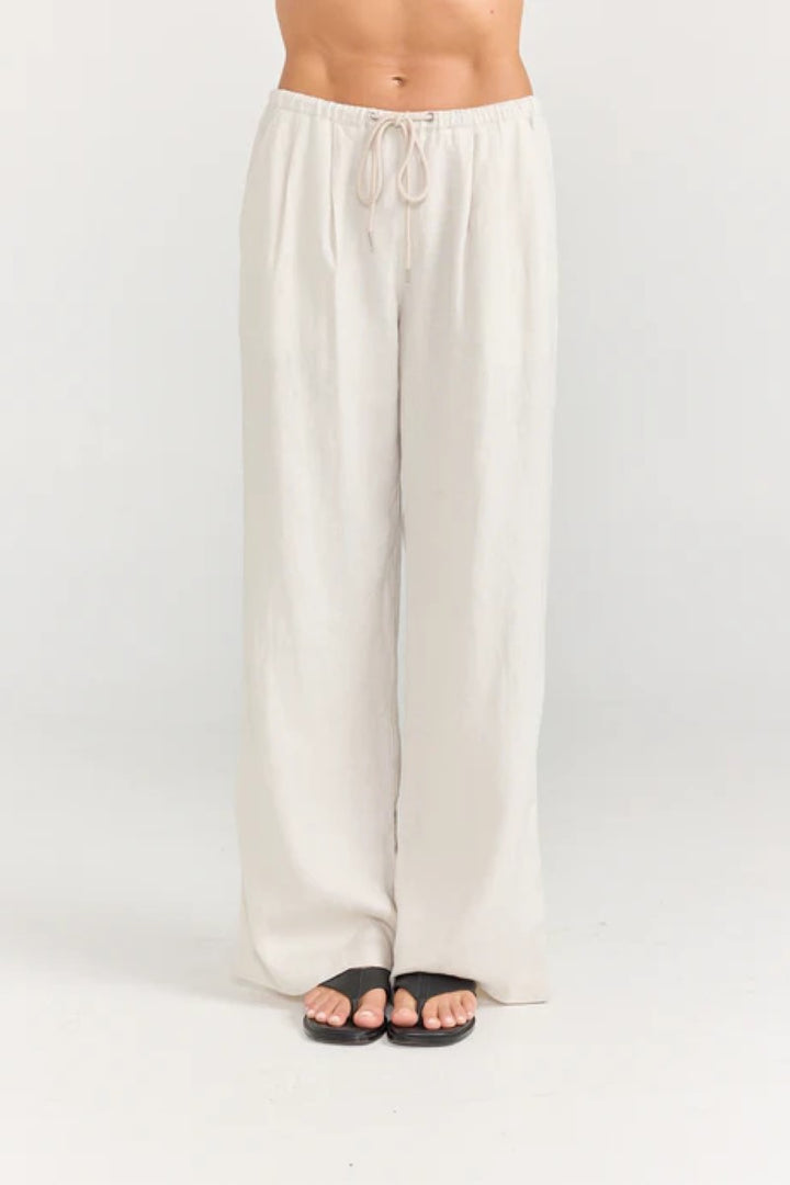 Beige wide-leg pants worn by a person on a white background